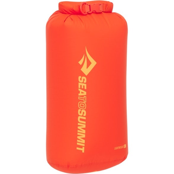 AquaVault 8L Ultralight Dry Pack, rolled down and clipped, sitting on a natural rock next to a flowing stream, highlighting its compact size and outdoor use.