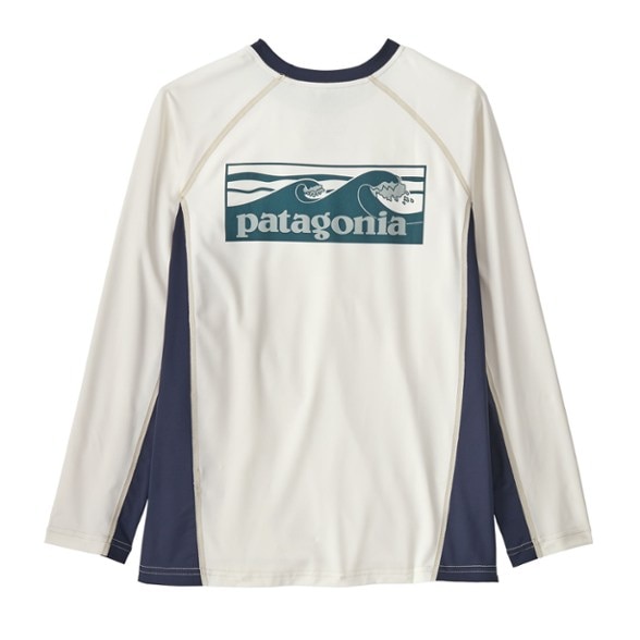 Kids wearing a long sleeve rashguard while surfing, showcasing comfort and flexibility.