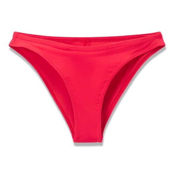 Woman wearing Vuori bikini bottoms with medium coverage while surfing