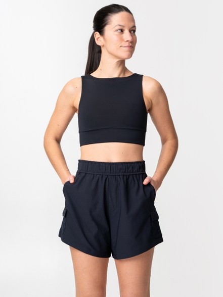 Alder Aqua Women's Quick Dry Shorts showcased by a model on a hiking trail, emphasizing the cargo pockets and high-rise design.