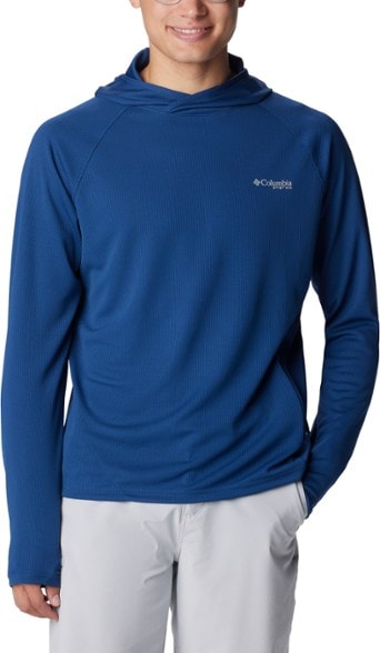 Columbia PFG Solar Stream Elite hoodie on a man hiking, highlighting sun protection features.