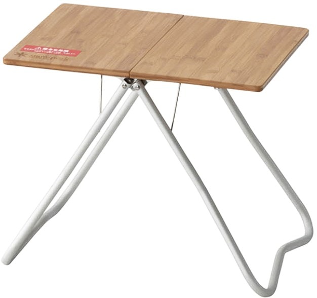 Lightweight camping table unfolded on grassy terrain, showcasing bamboo top and aluminum frame