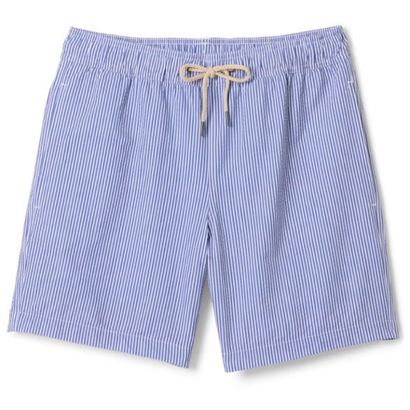 Side view of eco-friendly 7-inch swim trunks for men by the beach