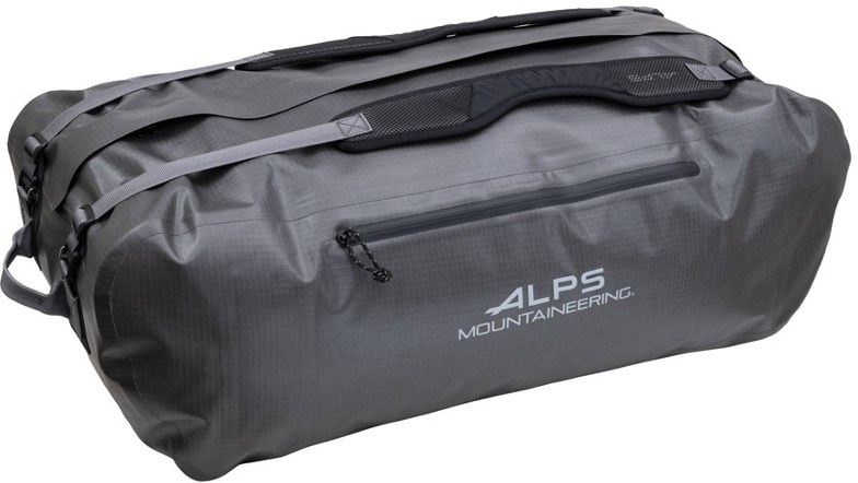 Cascade Pro 65L duffel bag in black, shown partially submerged in water to highlight its water-resistant capabilities, with a scenic lake and mountains in the background.
