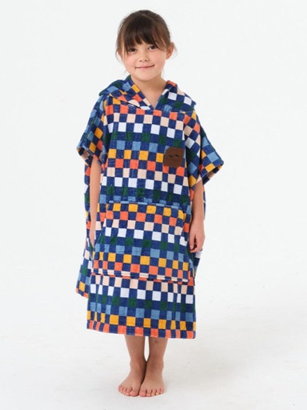Children wearing Sundown poncho at the beach, showcasing its soft cotton fabric.