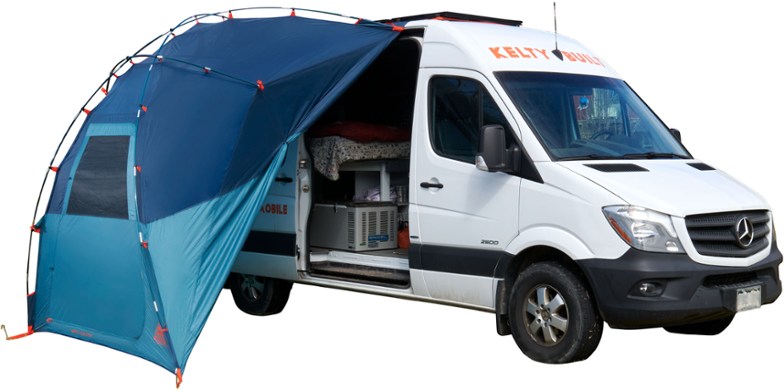 Kelty TrailPort Shelter fully assembled on the side of an SUV during sunset.