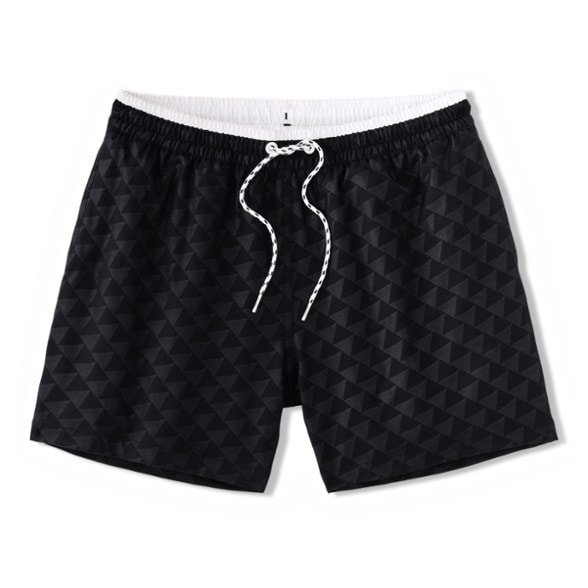 Men modeling classic navy swim trunks on a sunny beach, showcasing pocket design