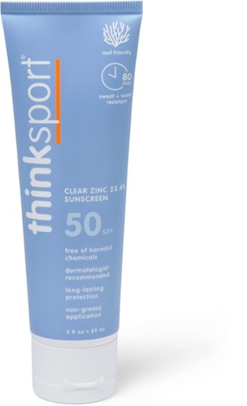 Thinksport SPF 50 sunscreen applied on a child's arm enjoying a sunny day at the beach.