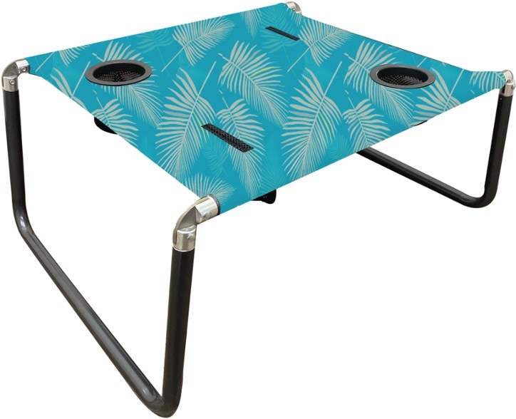 Neso portable beach table set up at the beach with snacks and drinks in cup holders.