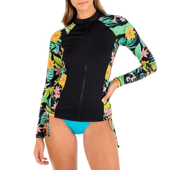 Woman surfing in Hurley UPF 50 rashguard showing full-zip front and sleeve details