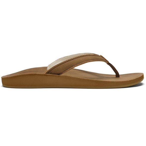 Side view of OluKai women's Southshore flip-flops on a sandy beach.