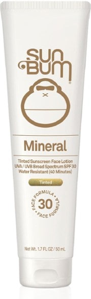 Sun Shield Tinted SPF 30 Mineral Sunscreen Lotion bottle against a beach backdrop.