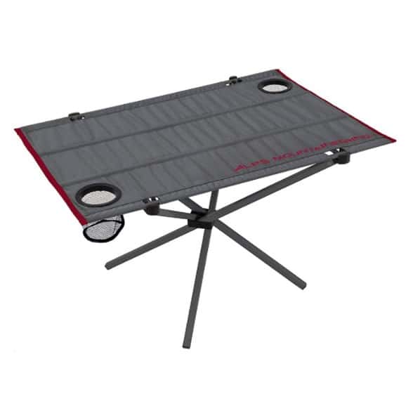 Folding camping table with cup holders in use at a campsite