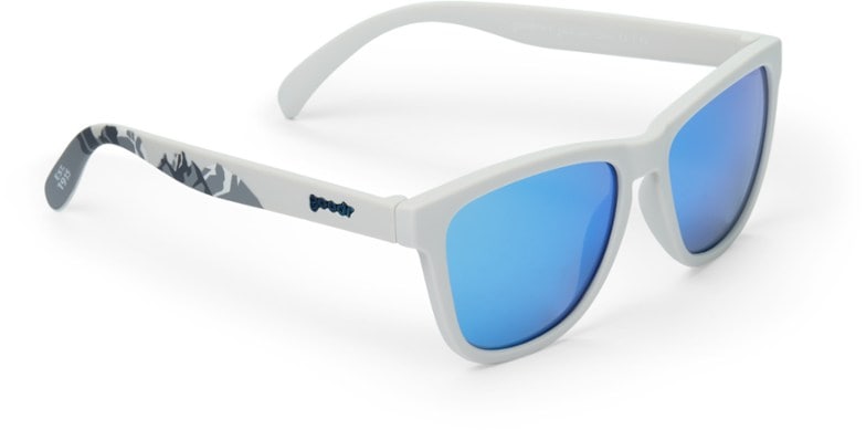 Close-up of polarized sunglasses resting on a backpack during a hiking trip