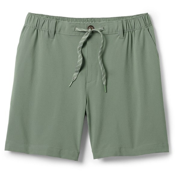 Men modeling versatile quick dry shorts on rocky coastline, demonstrating pocket storage