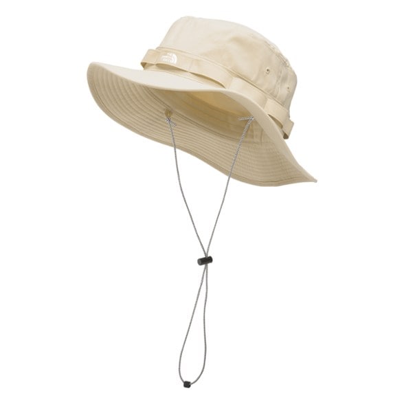 Unisex UPF protection hat worn on a sunny beach with ocean backdrop