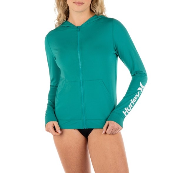 Women wearing blue OAO zip hoodie rashguard while surfing, demonstrating sun protection