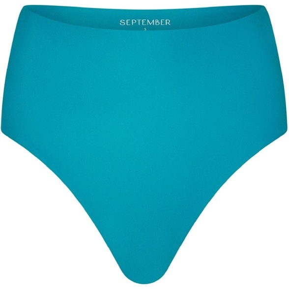 Woman wearing Luna high-waisted surf bikini bottoms while surfing