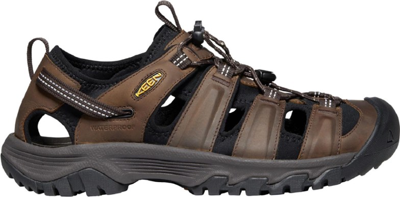KEEN Targhee III men's sandals on a rocky trail, showcasing their waterproof design and high-traction grip.