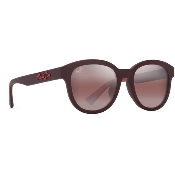 A person wearing Maui Jim Ihupani Low-Bridge Fit polarized sunglasses, smiling and enjoying a clear, sunny outdoor setting.
