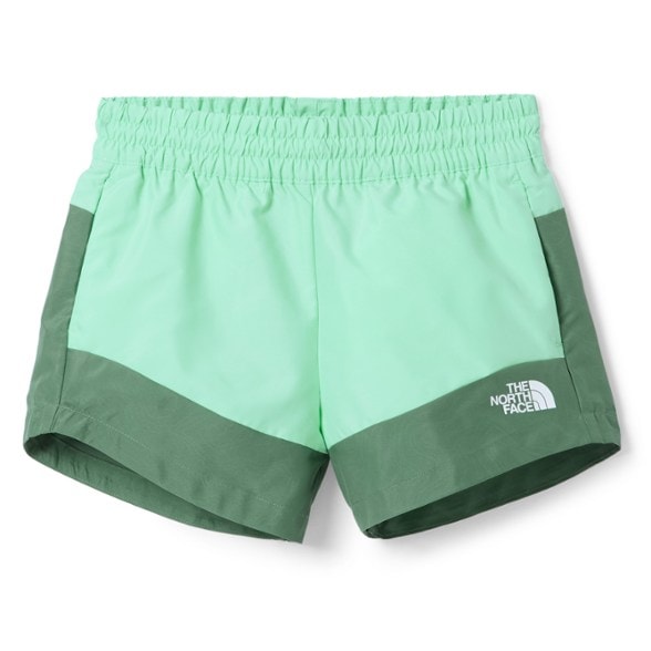 Young girl wearing The North Face Wanderer Eco Quick-Dry Shorts in a vibrant blue, standing by a lake, showcasing the quick-dry fabric.