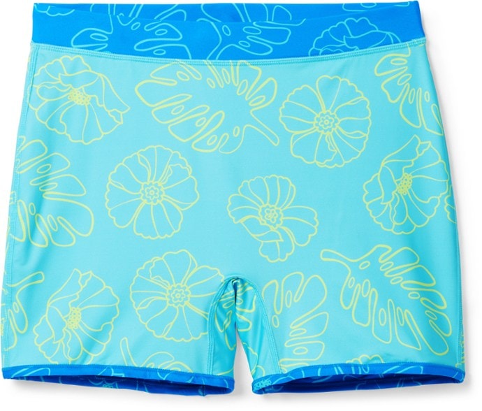 Women wearing reversible swim shorts by the pool, showing both color options