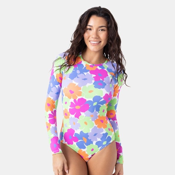 Side view of women's long sleeve swimsuit on the beach, highlighting fitted silhouette