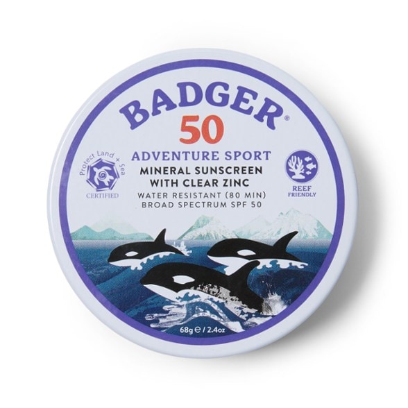 Close-up of the Adventure Shield SPF 50 Mineral Sport Sunscreen tin, highlighting its natural finish on a sandy beach background, ready for water sports.