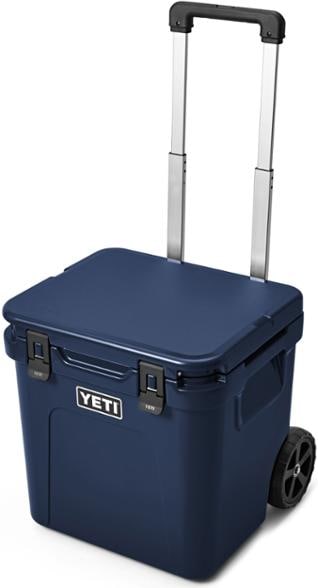 YETI Roadie 48 wheeled cooler rolling across sandy beach with drinks inside